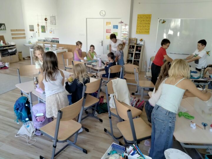 Deti v triede pracujú pri stoloch samostatne aj v skupinkách, medzi nimi sa pohybuje sprievodkyňa